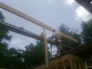 Carpenter setting a ridge beam over a new addition frame — Ice Dam Removal by Roofing Brothers in Wyncote