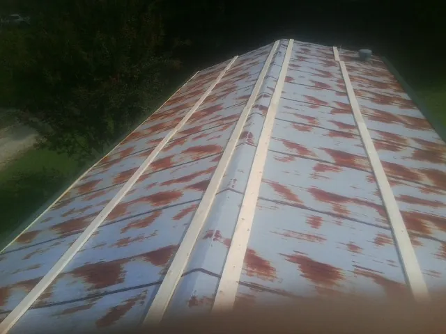 Rusted metal roof panels with new wood purlins before replacement — Storm Damage Roof Repair in Wyncote by Roofing Brothers