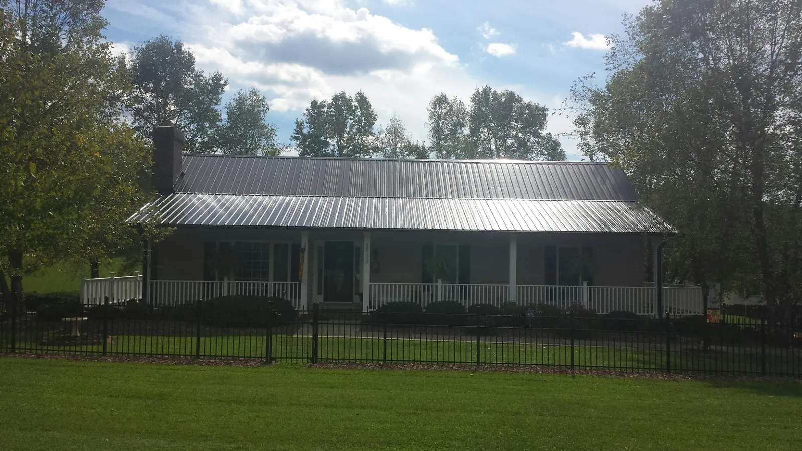 Gray metal roof on a brick ranch with a full width front porch — Gutter Guard Installation work by our crew in Wyncote